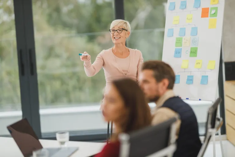 Woman presenting a sticky-note plan to her small business team