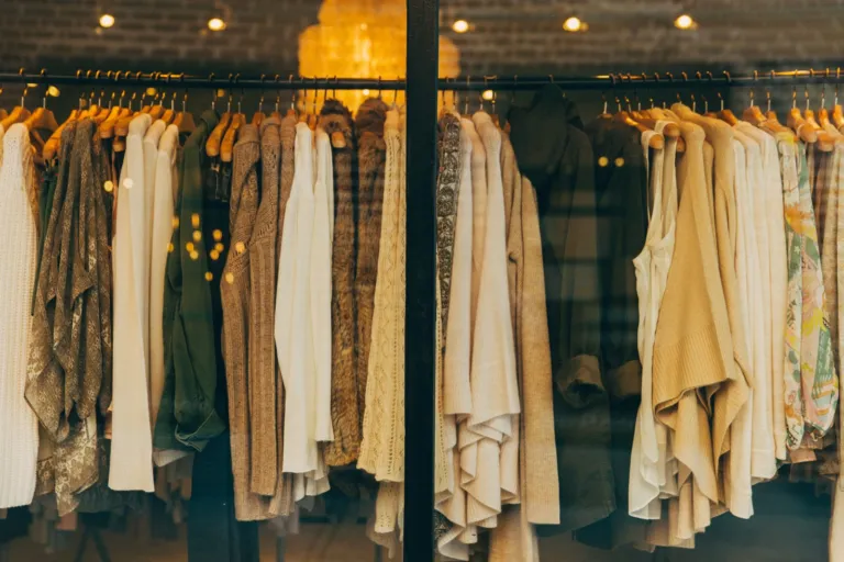 Neutral-toned clothing hanging on rails in a boutique