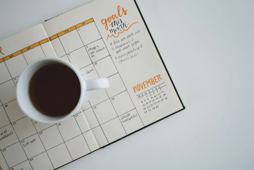 Coffee mug resting on an open weekly planner