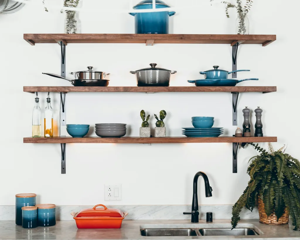 Small kitchen with cookware neatly arranged on floating shelves
