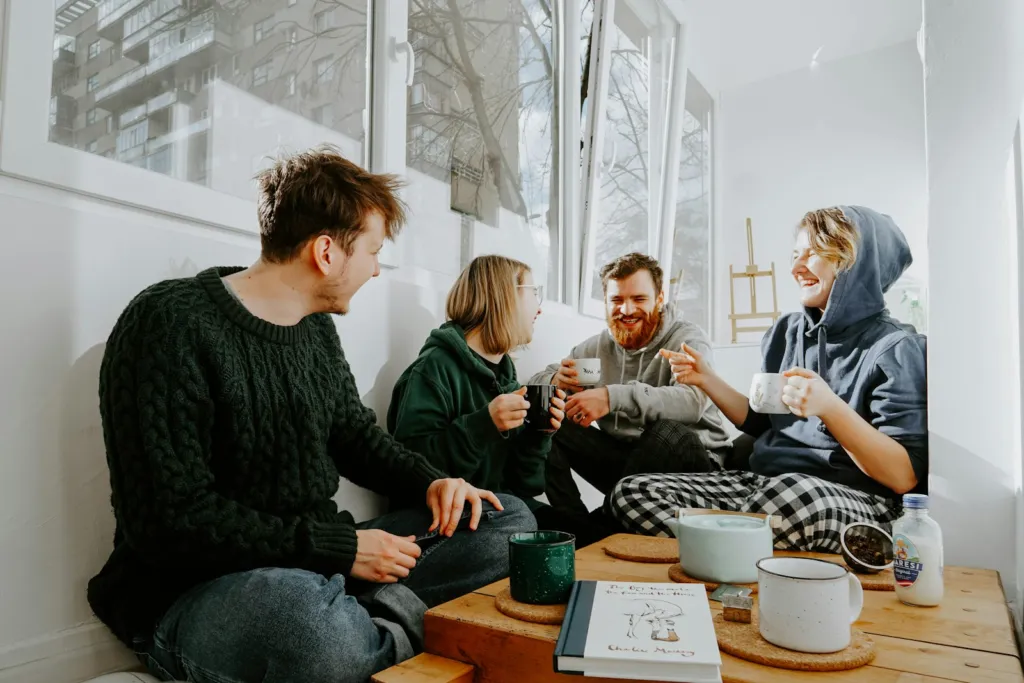 Group of friends talking and laughing around a wooden table