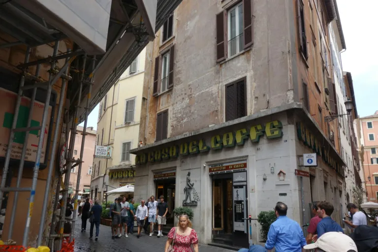 People walking past a cafe on a narrow old town street