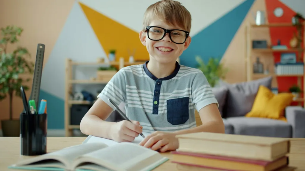 Confident, smiling student at his desk after a productive session with Math Tutors.org