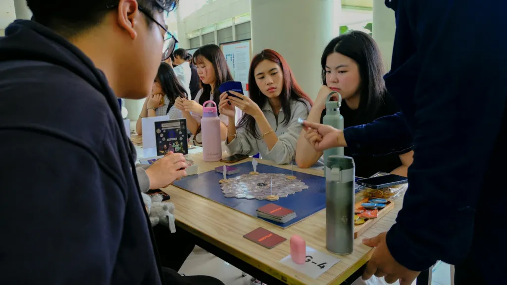 Group of people playing a board game around a table indoors