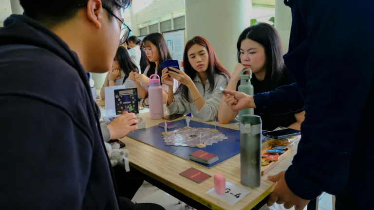 Group of people playing a board game around a table indoors
