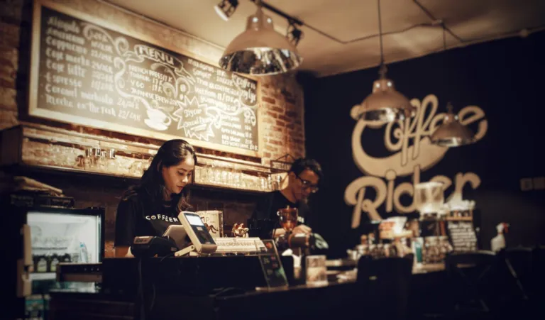 Staff working behind the counter of a cozy small coffee shop